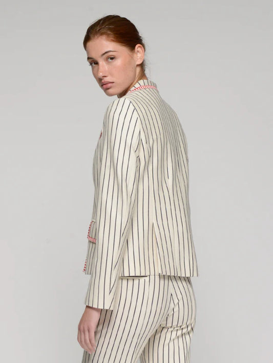 Woman wearing a striped suit on a plain background