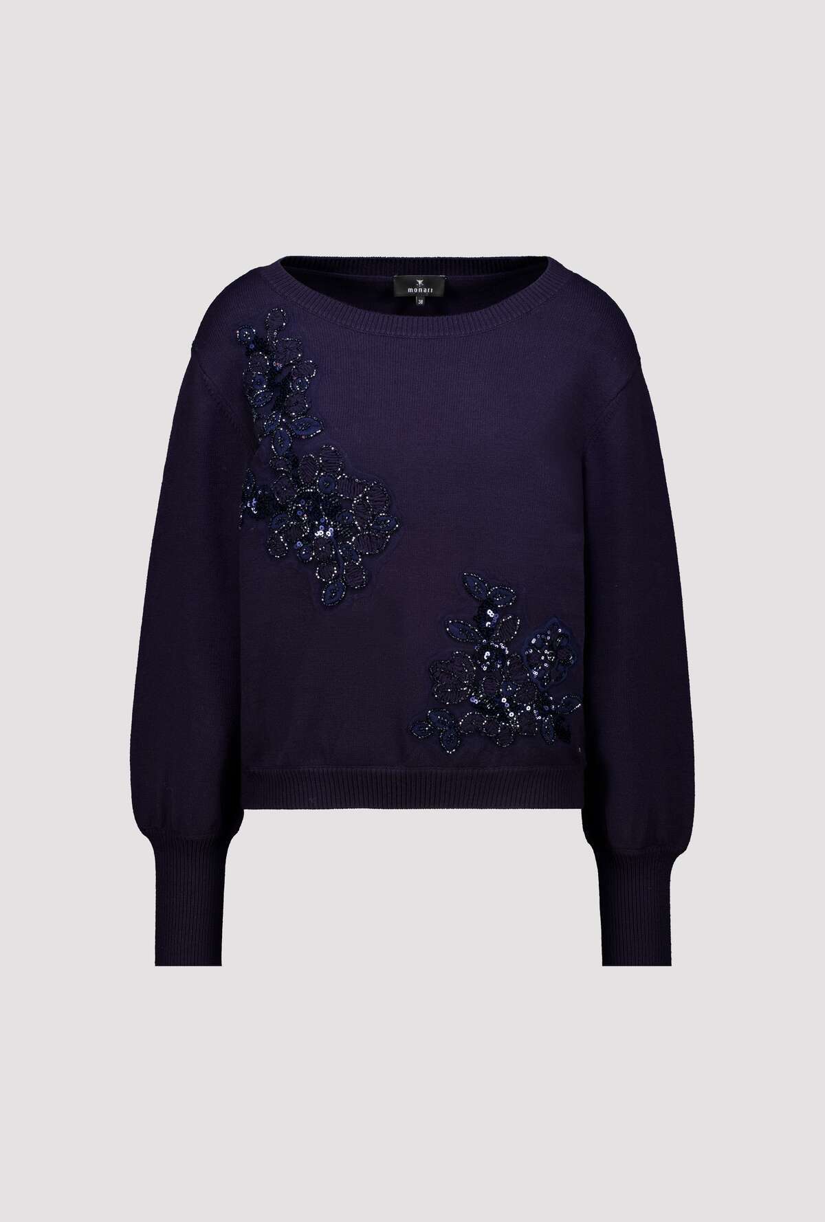 A dark purple long-sleeve knit sweater with intricate dark blue and silver beaded floral embellishments on the front, displayed against a solid light gray background.