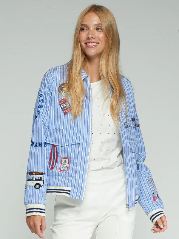 Woman wearing a blue pinstripe summer jacket with patches on a gray background