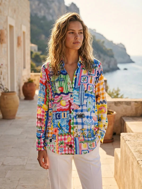 Woman wearing a colorful patterned shirt standing outdoors with scenic background