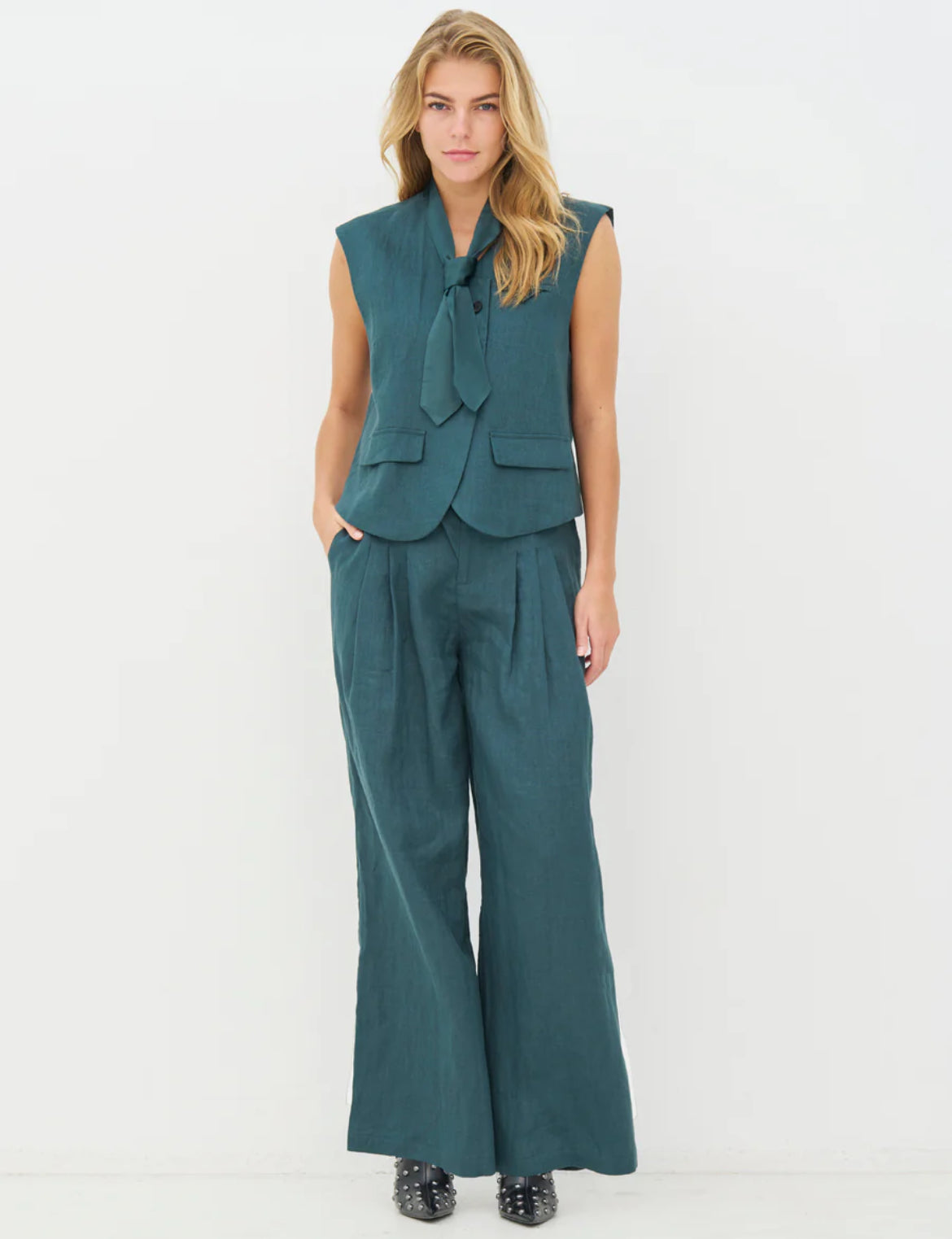 Woman wearing a teal suit with a vest and wide-leg pants all 100% linen