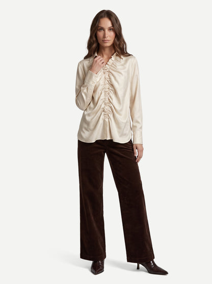 A woman modelling dark brown wide-leg velvet pants from Nu Denmark 