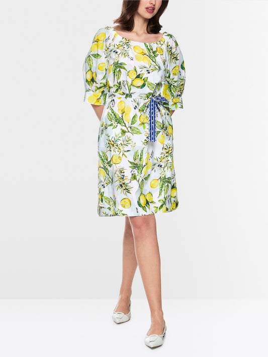 Woman wearing a floral dress with lemon pattern on a white background