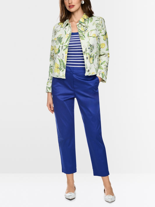 Woman wearing a floral jacket, striped shirt, and blue pants on a white background