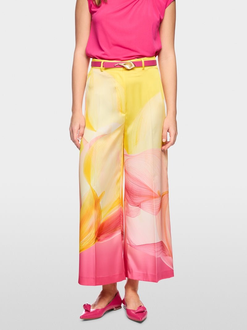 Woman wearing a colorful floral skirt with a pink top on a white background