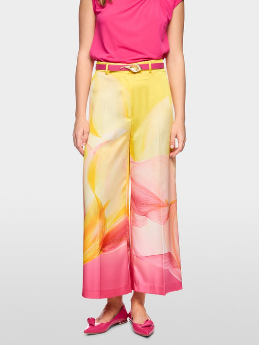 Woman wearing a colorful floral skirt with a pink top on a white background