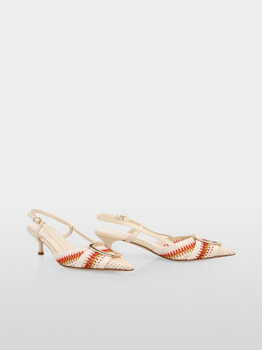 Pair of beige high-heeled shoes with red and white striped pattern on a light gray background