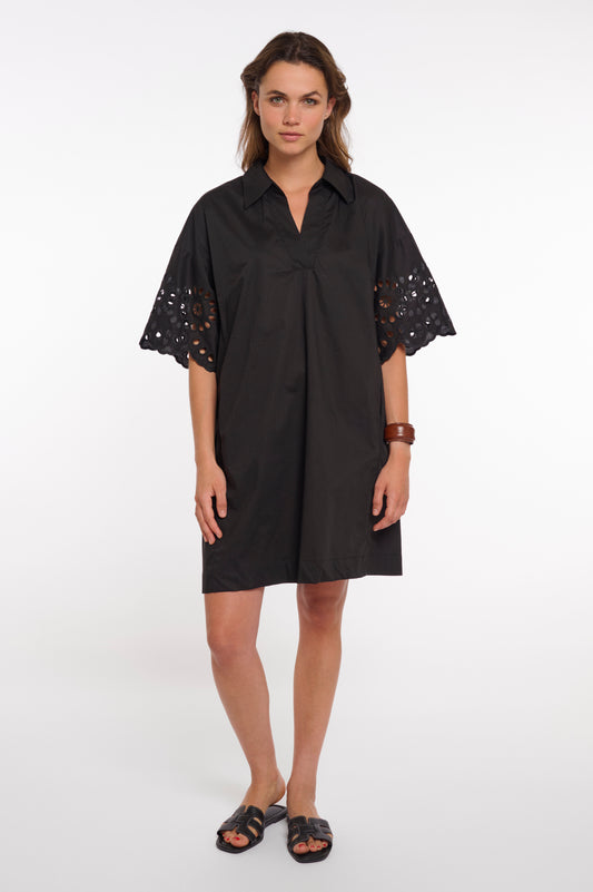 Woman wearing a black dress with lace sleeves on a white background