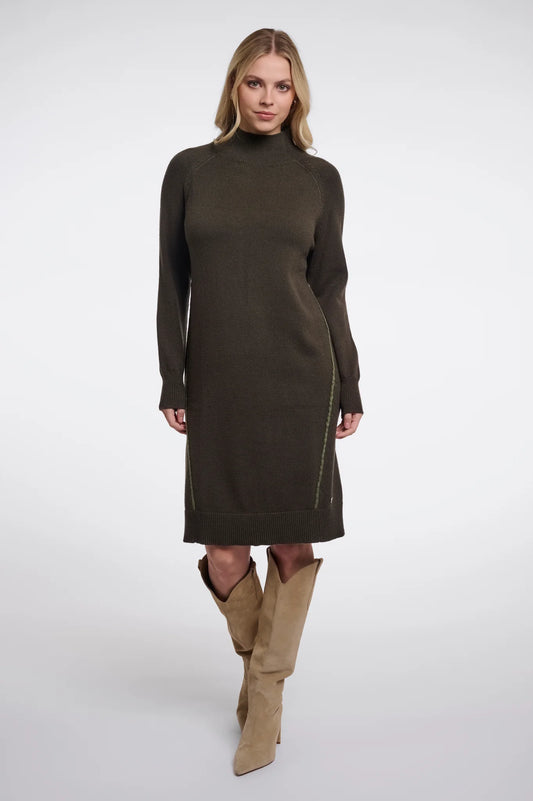 A woman modeling a dark olive green mock-neck knit sweater dress with side zip details, paired with tan knee-high boots, against a light gray studio background.