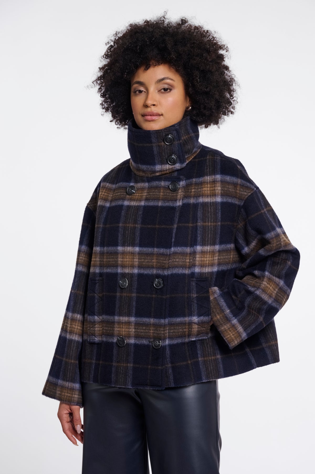 a cropped, double-breasted plaid coat with a high mock neck collar. The coat features a navy blue base with brown, beige, and light blue plaid stripes.