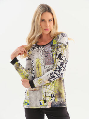 Long-sleeve abstract patchwork top with black, yellow, gray, and white tones, paired with black pants,