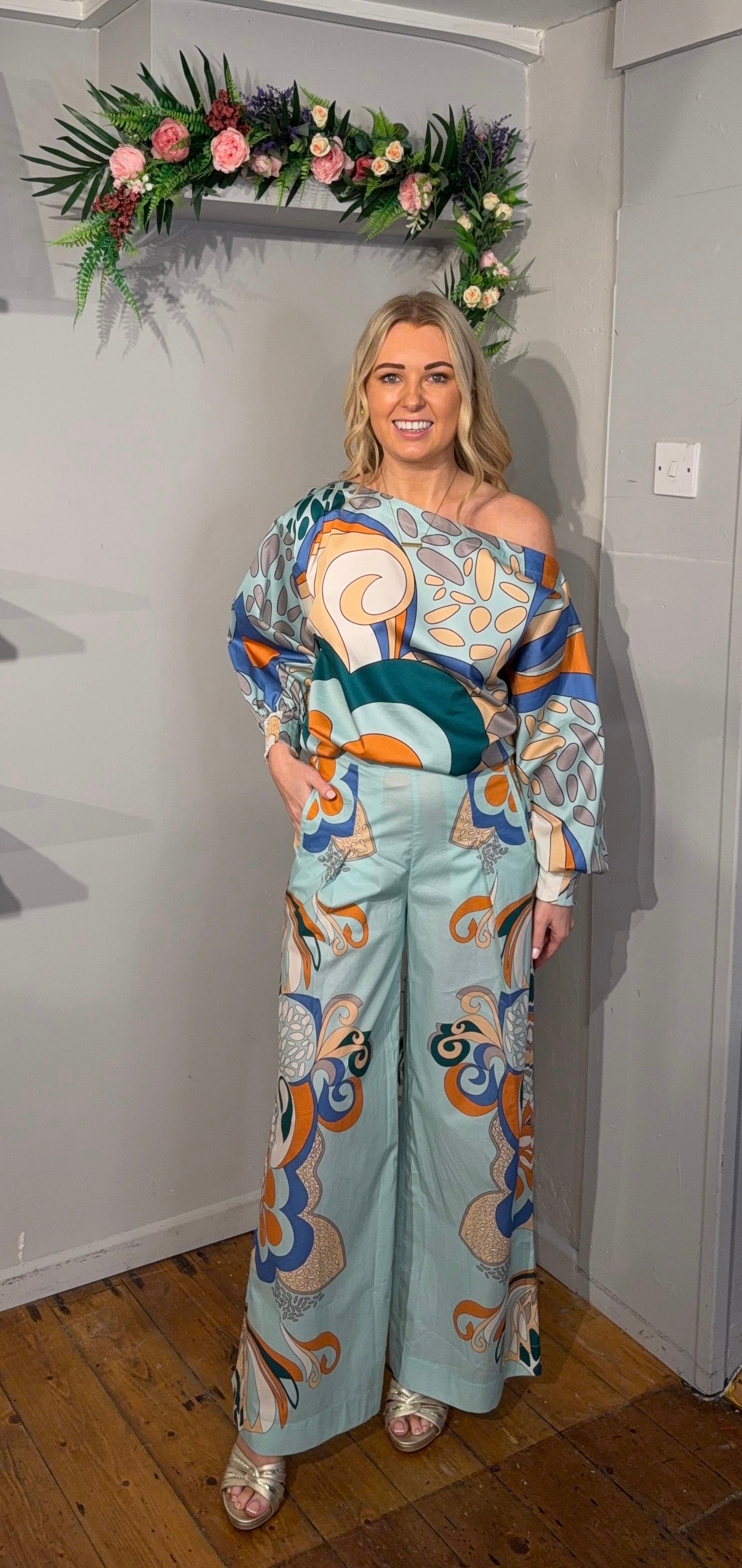 Wide-leg 100% cotton trousers with high waist and retro print in aqua, blue and orange tones, featuring side pockets.