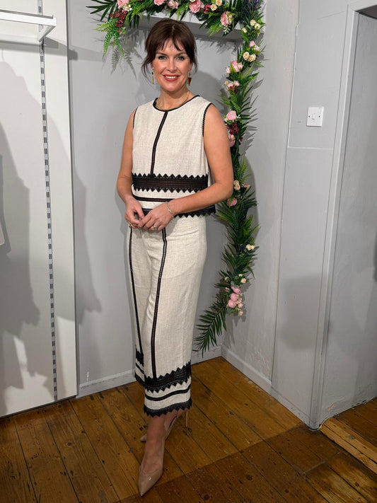 Woman in a white and black top and pants suit 